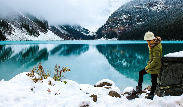 Girl hiking by a lake in snow